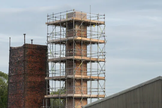 Scaffold built around a tall brick chimney